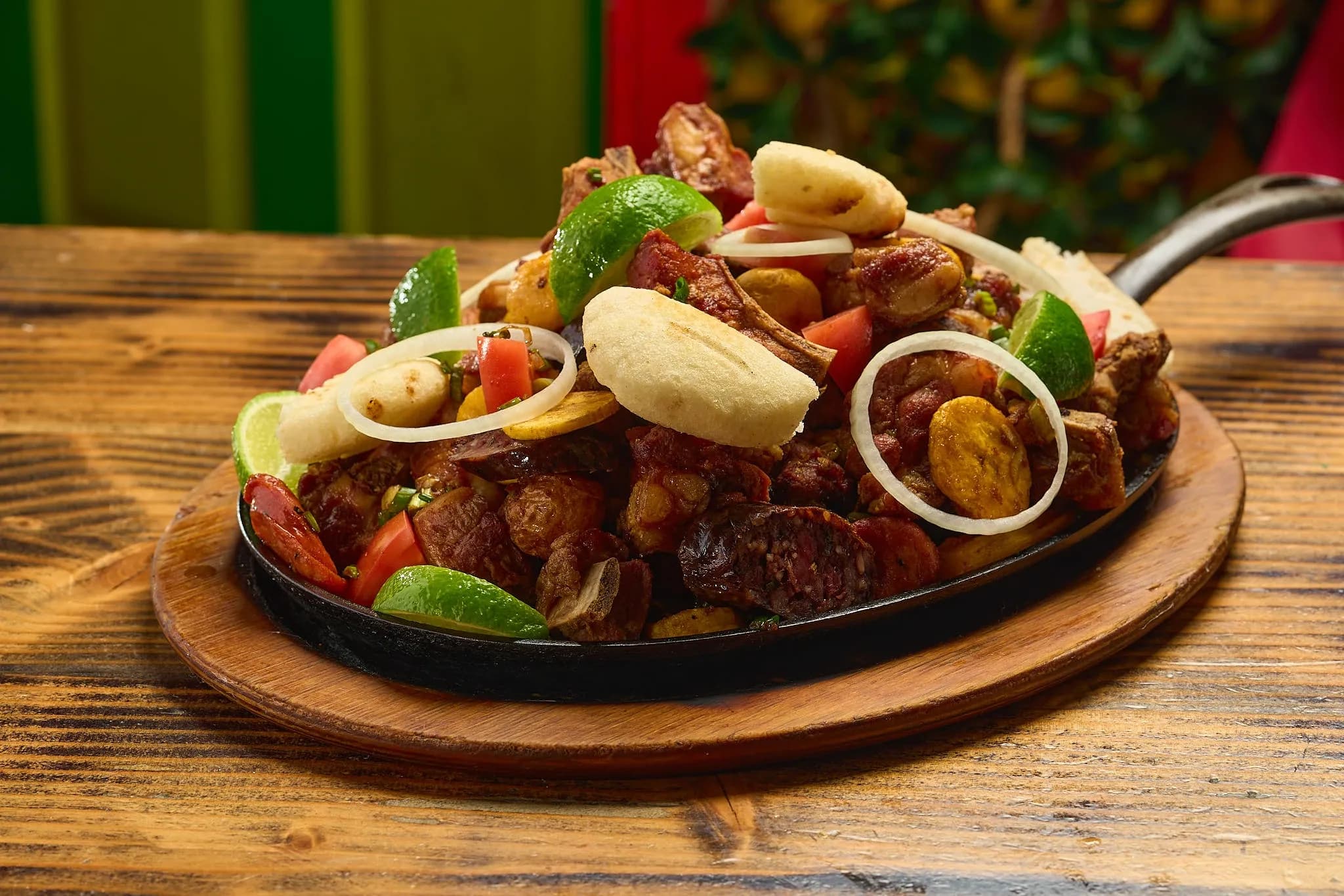 Picada de carnes on a sizzling platter at La Choza Del Gordo